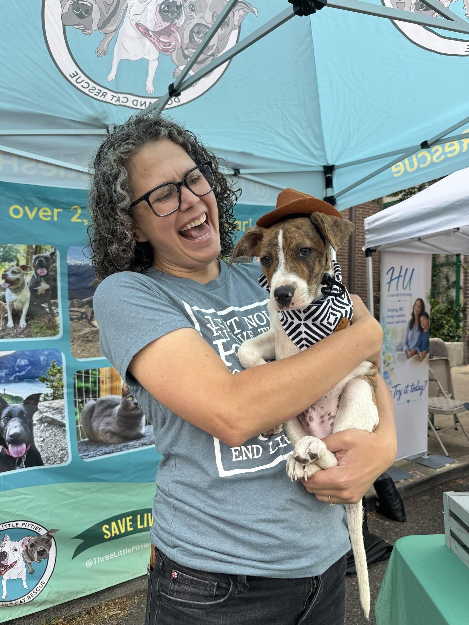 Pacific Northwest foster volunteer holding a rescue puppy at a community event