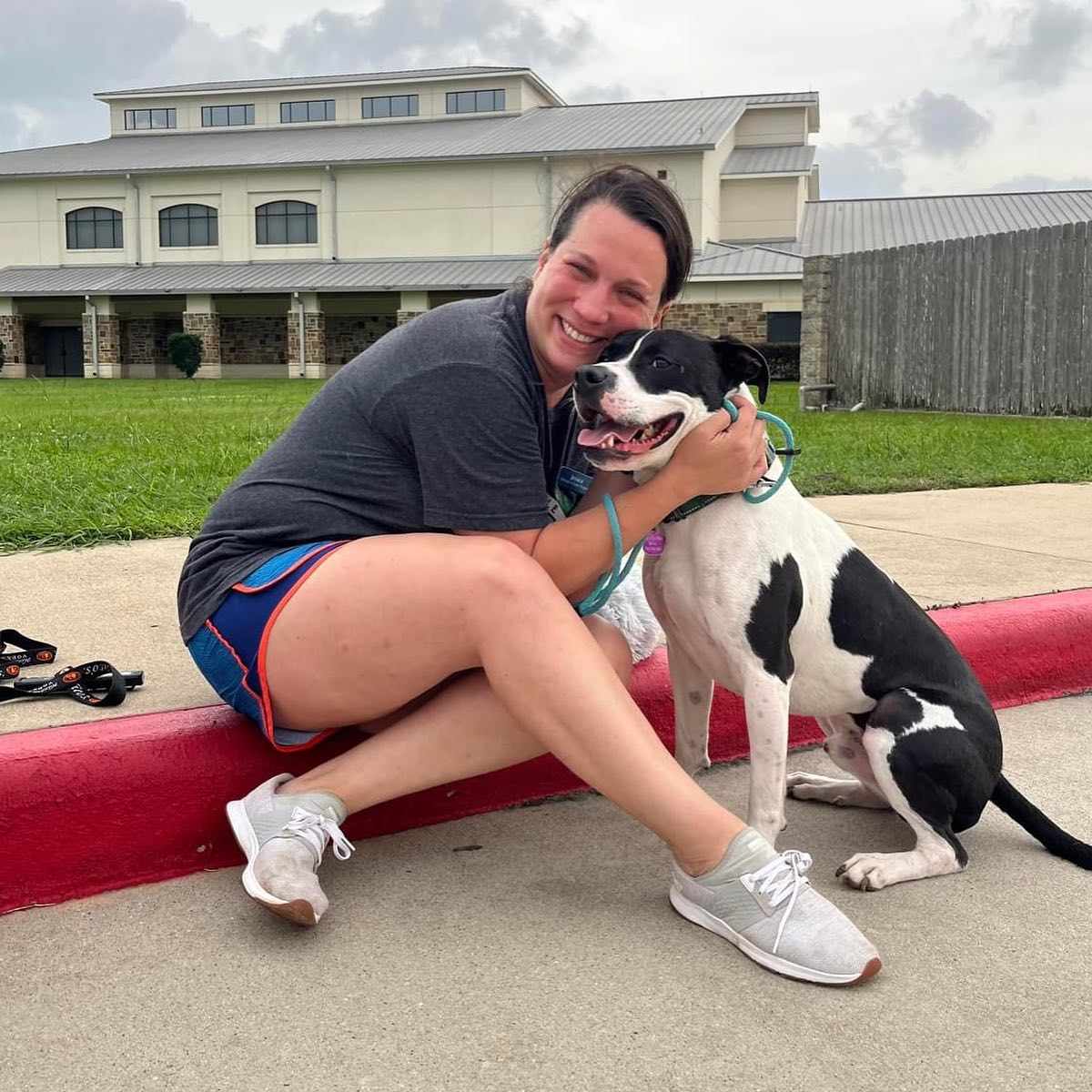 A volunteer welcoming a transported dog at the Friendswood loading site